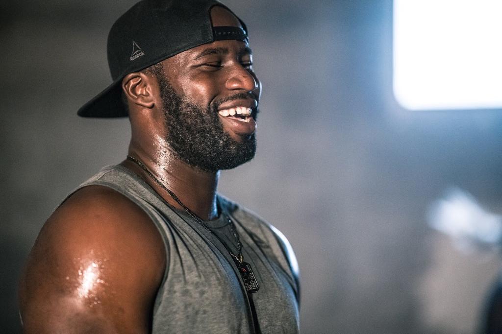 Man with a hat on sweating & smiling